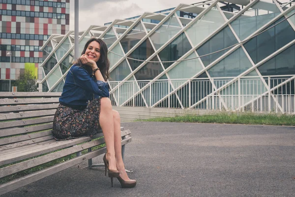 Güzel kız sokakta bir bankta oturmuş — Stok fotoğraf
