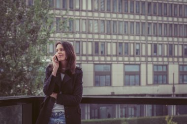 Güzel kız şehir sokaklarında telefonda konuşuyor