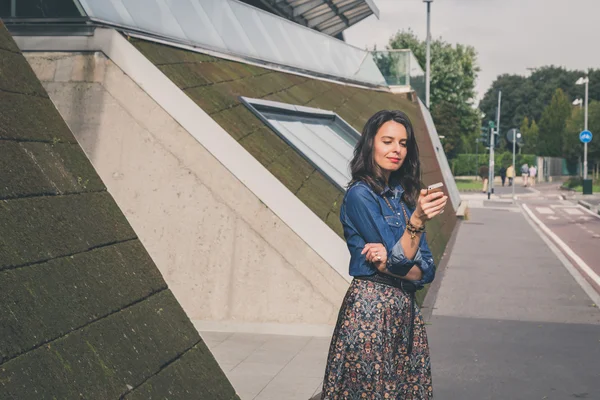 Jolie fille textos dans les rues de la ville — Photo