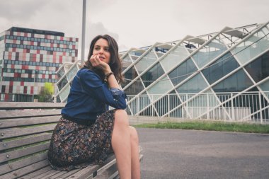 Güzel kız sokakta bir bankta oturmuş