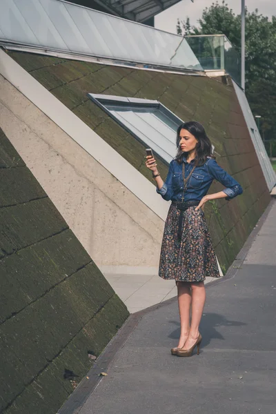 Bella ragazza sms per le strade della città — Foto Stock