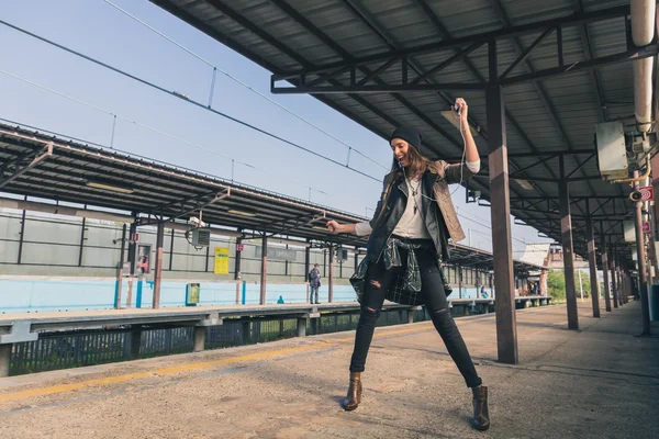 Jolie fille écoutant de la musique dans une station de métro — Photo