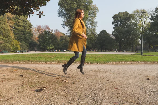 Redhead girl jumping in a city park — Stock Photo, Image