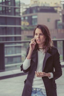 Güzel kız şehir sokaklarında telefonda konuşuyor