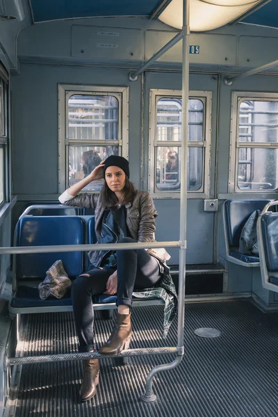 Pen jente som poserer i en metrobil. – stockfoto