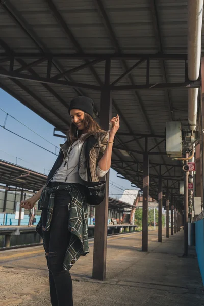 Menina bonita ouvir música em uma estação de metro — Fotografia de Stock