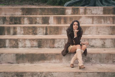 Somut adımlar üzerinde oturan güzel genç kadın