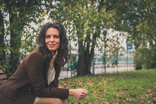Beautiful young woman posing in a city park — Stock Photo, Image