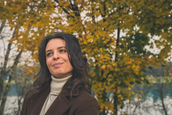 Beautiful young woman posing in a city park — Stock Photo, Image