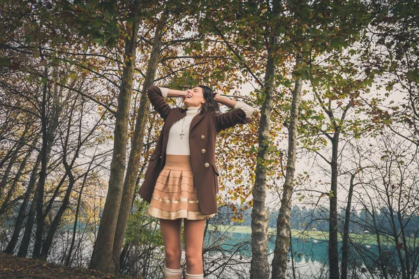 Beautiful young woman posing in a city park — Stock Photo, Image