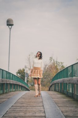 Güzel genç kadın bir köprüde poz
