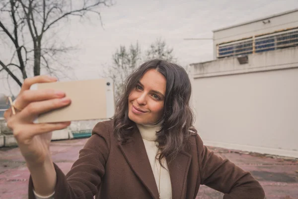 Vacker ung kvinna med en selfie — Stockfoto