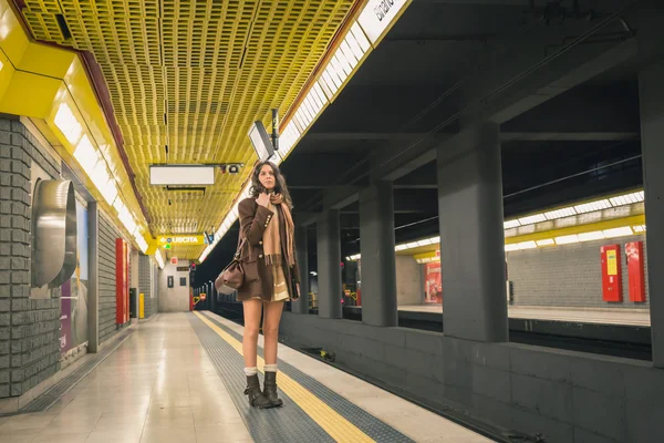 Beautiful young woman posing in a metro station — Stock Photo, Image