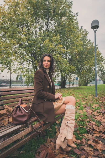 Beautiful young woman posing in a city park — Stock Photo, Image