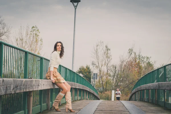 Beautiful young woman posing on a bridge — Stock Photo, Image