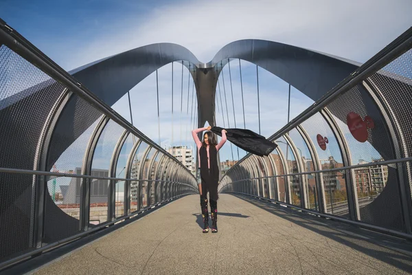 Beautiful young brunette posing on a bridge — Stock Photo, Image