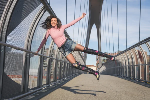 Krásná mladá brunetka skákání na most — Stock fotografie