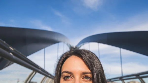 Dettaglio di una bella giovane bruna in posa su un ponte — Foto Stock