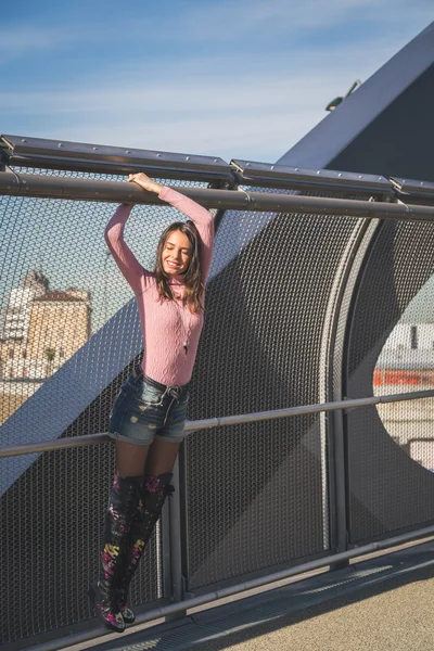 Belle jeune brune posant sur un pont — Photo