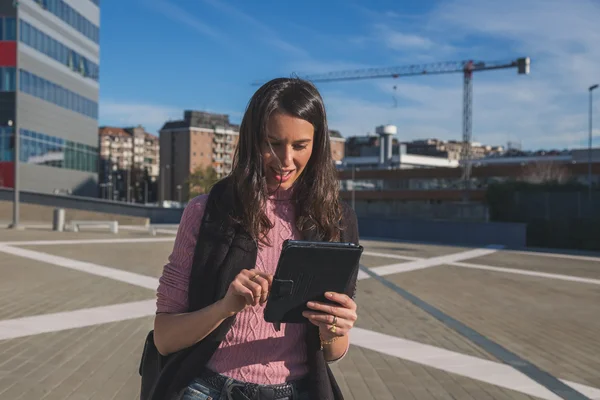 Krásná mladá brunetka pracuje na její tablet — Stock fotografie