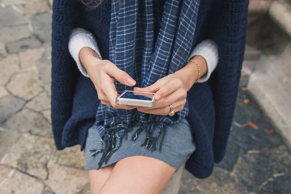 Detail van een mooi meisje texting in de straten van de stad — Stockfoto