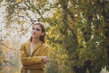 Kızıl saçlı kız bir şehir parkında poz