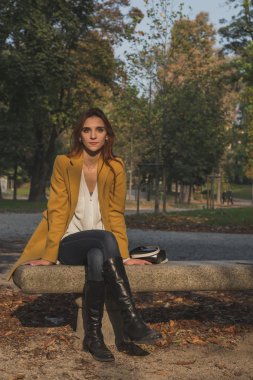 Kızıl saçlı kız bir şehir parkında poz
