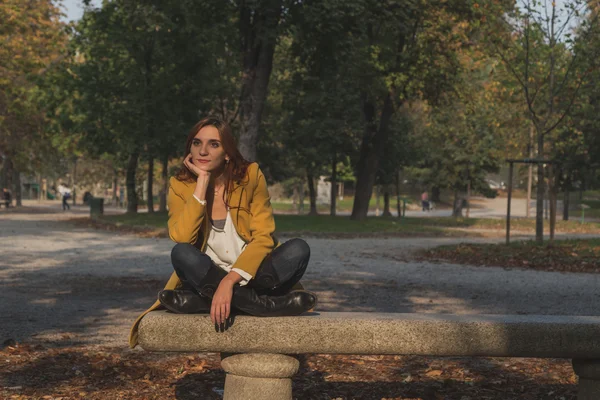 Rödhårig tjej poserar i en park — Stockfoto