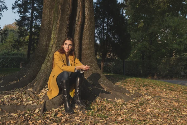 Roodharige meisje poseren in een stadspark — Stockfoto