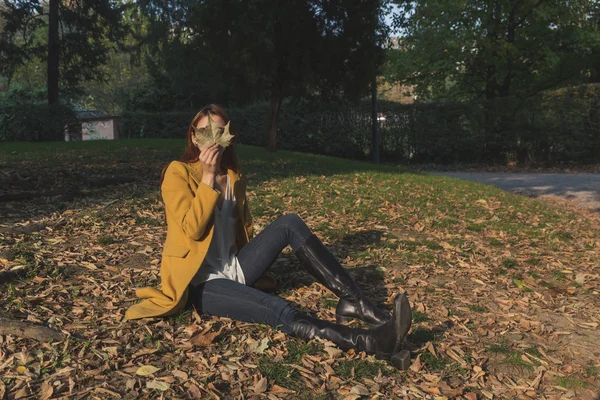 Roodharige meisje poseren in een stadspark — Stockfoto