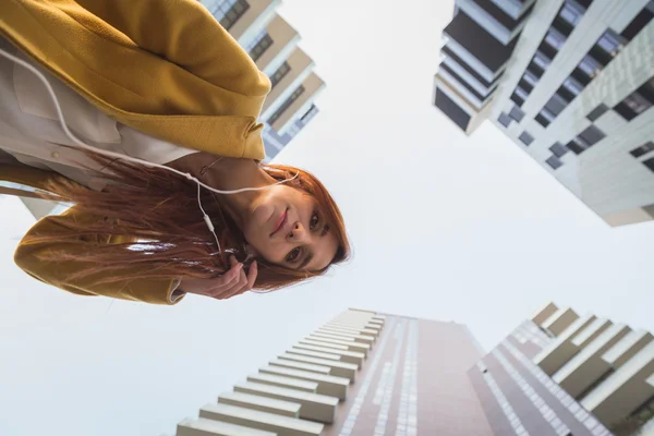 Kızıl saçlı kız şehir sokaklarda müzik dinlemek — Stok fotoğraf