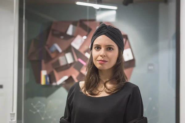 Beautiful young brunette posing in an office — Stock Photo, Image