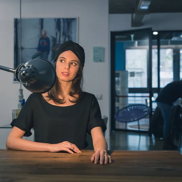 Beautiful young brunette posing in an office — Stock Photo, Image