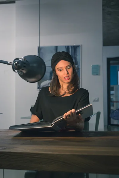 Beau livre de lecture jeune brune dans un bureau — Photo