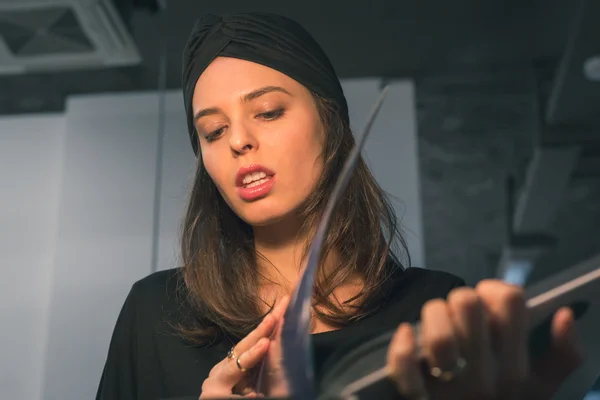 Mooie jonge brunette lezing boek in een kantoor — Stockfoto