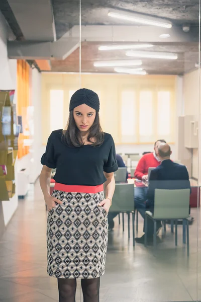 Beautiful young brunette posing in an office — Stock Photo, Image