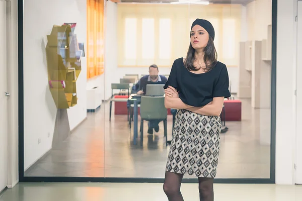 Beautiful young brunette posing in an office — Stock Photo, Image