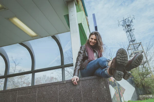 Schöne junge Brünette posiert in den Straßen der Stadt — Stockfoto