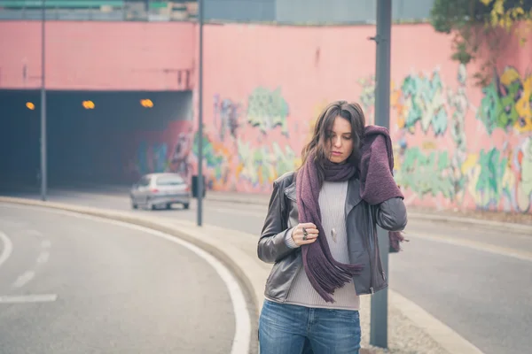 Krásná mladá brunetka pózuje v ulicích města — Stock fotografie