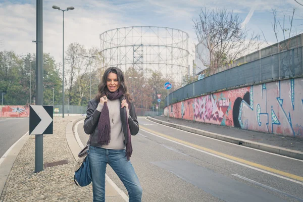 Krásná mladá brunetka pózuje v ulicích města — Stock fotografie