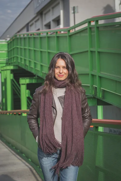 Beautiful young brunette posing on a bridge — Stock Photo, Image