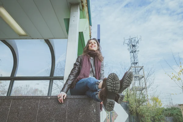 Vakker ung brunette som poserer i byens gater – stockfoto