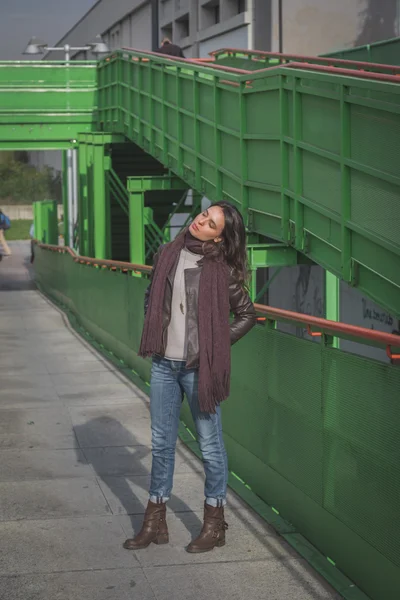Beautiful young brunette posing on a bridge — Stock Photo, Image