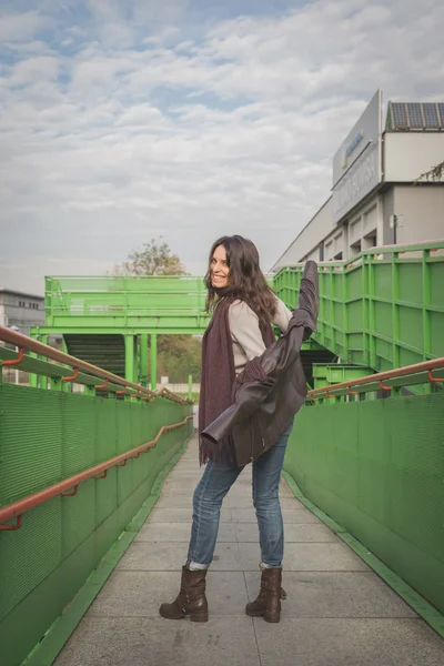 Schöne junge Brünette posiert auf einer Brücke — Stockfoto