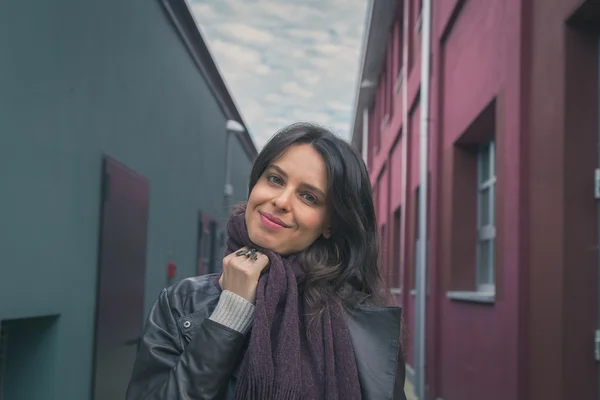 Schöne junge Brünette posiert in den Straßen der Stadt — Stockfoto