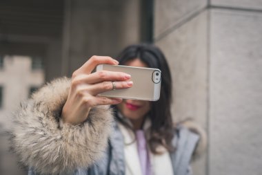 Güzel genç esmer bir selfie şehir sokaklarını alarak