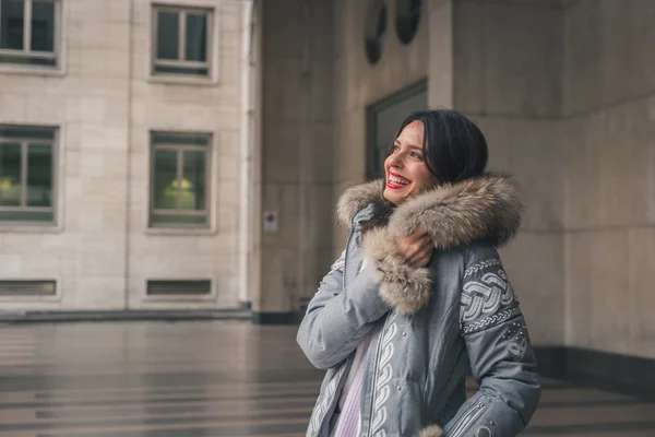 Krásná mladá brunetka pózuje v ulicích města — Stock fotografie