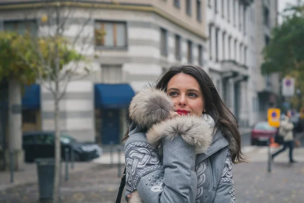 Krásná mladá brunetka pózuje v ulicích města — Stock fotografie