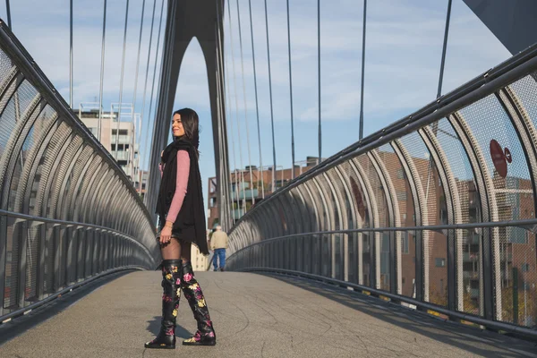 Mooie jonge brunette die zich voordeed op een brug — Stockfoto