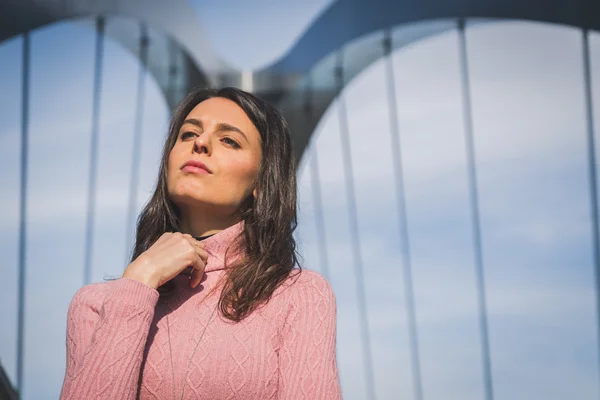 Mooie jonge brunette die zich voordeed op een brug — Stockfoto